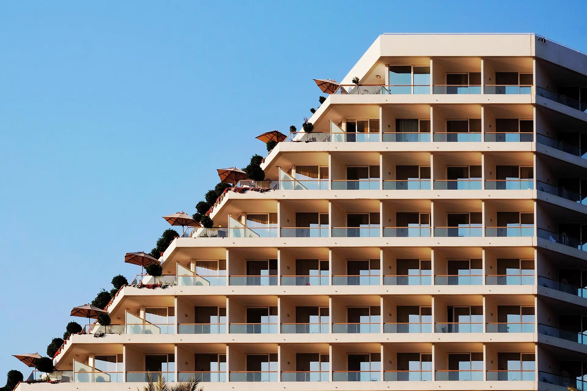 Terasasta fasada apartmanske zgrade s balkonima i suncobranima